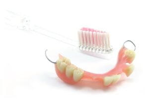 Denture and a toothbrush