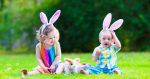 Two kids dressed up for easter sitting in grass