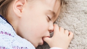 Young child sucking their thumb in their sleep